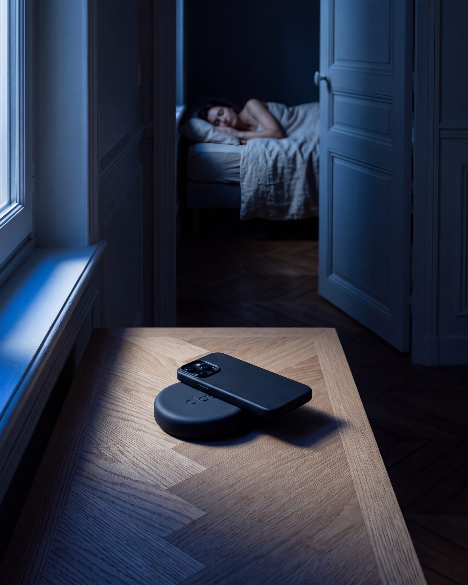 Le Clac sur une table de chevet la nuit, entouré d'une fine lueur bleue