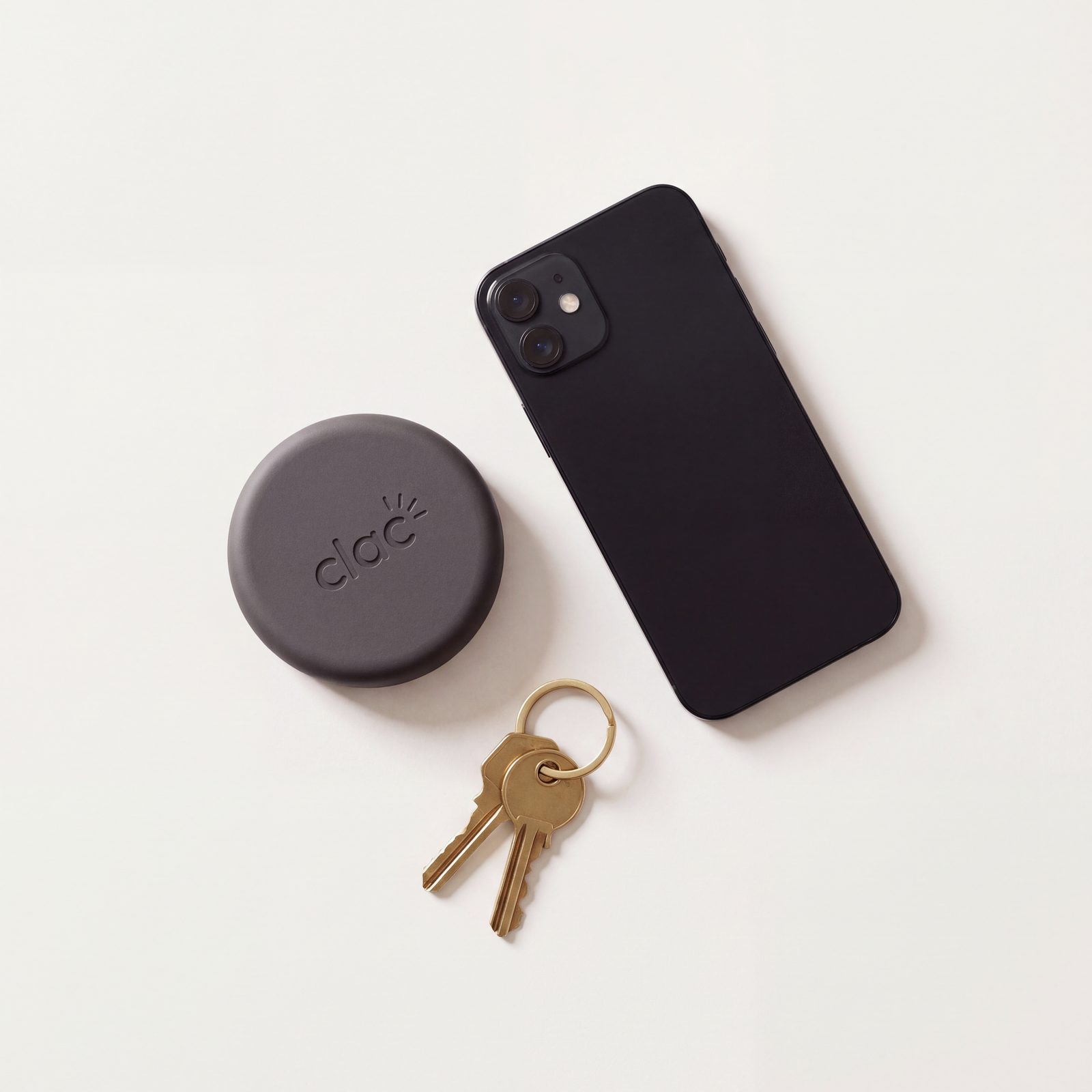 Vue de dessus du Clac à côté d'un iPhone et d'un trousseau de clés, pour l'échelle